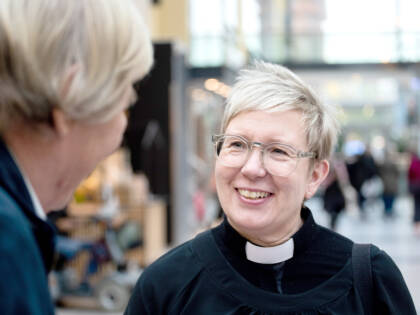 Pappi keskustelee seurakuntalaisen kanssa.