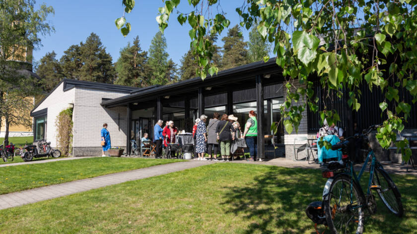 Ihmisiä Kirkonmäen seurakuntatalon pihalla kesällä.