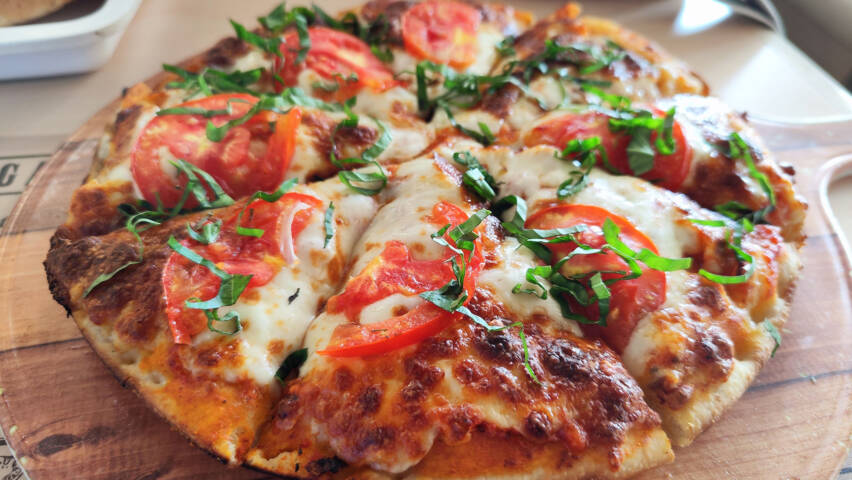 Paloiksi leikattu pizza lautasella.